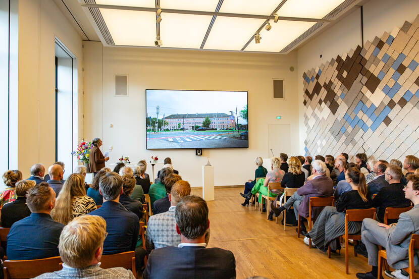 De zaal kijkt aandachtig naar filmpje over het Zuidergymnasium